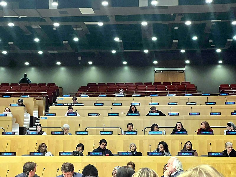 A tiered conference hall at United Nations Headquarters filled with delegates at their desks.